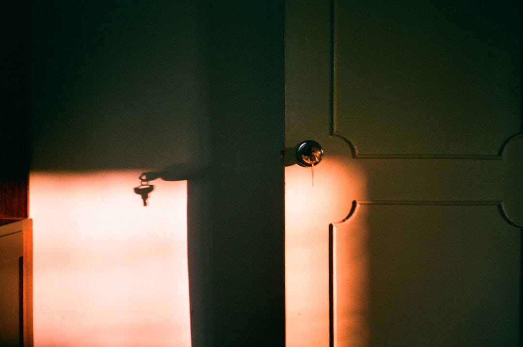 Close-up of a person's hand using a key to unlock the front door of a modern, stylish home, representing the basic functio...