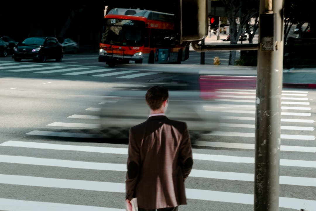 Professionally dressed person stands at a fork in the road or a split in a modern architectural path, symbolizing the impo...